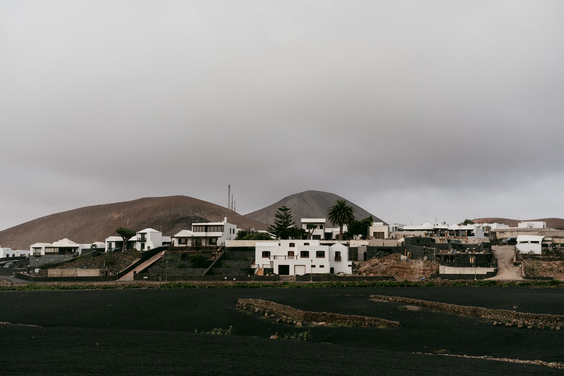 Roof of an Azorean home with solar panels and a heat-pump unit installed, overlooking the Atlantic
