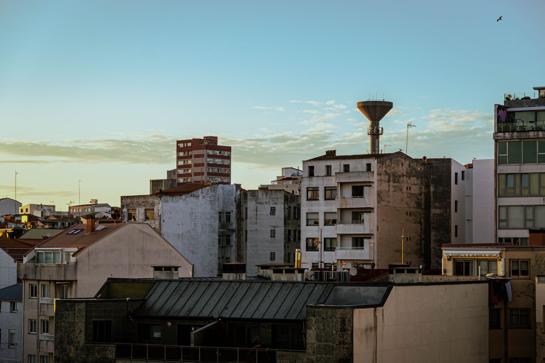 Rua estreita numa localidade açoriana com casas coloridas e o Atlântico ao fundo